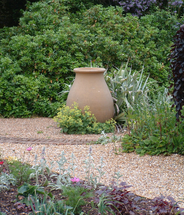An urn with planting in Denmans Garden by John Brookes.