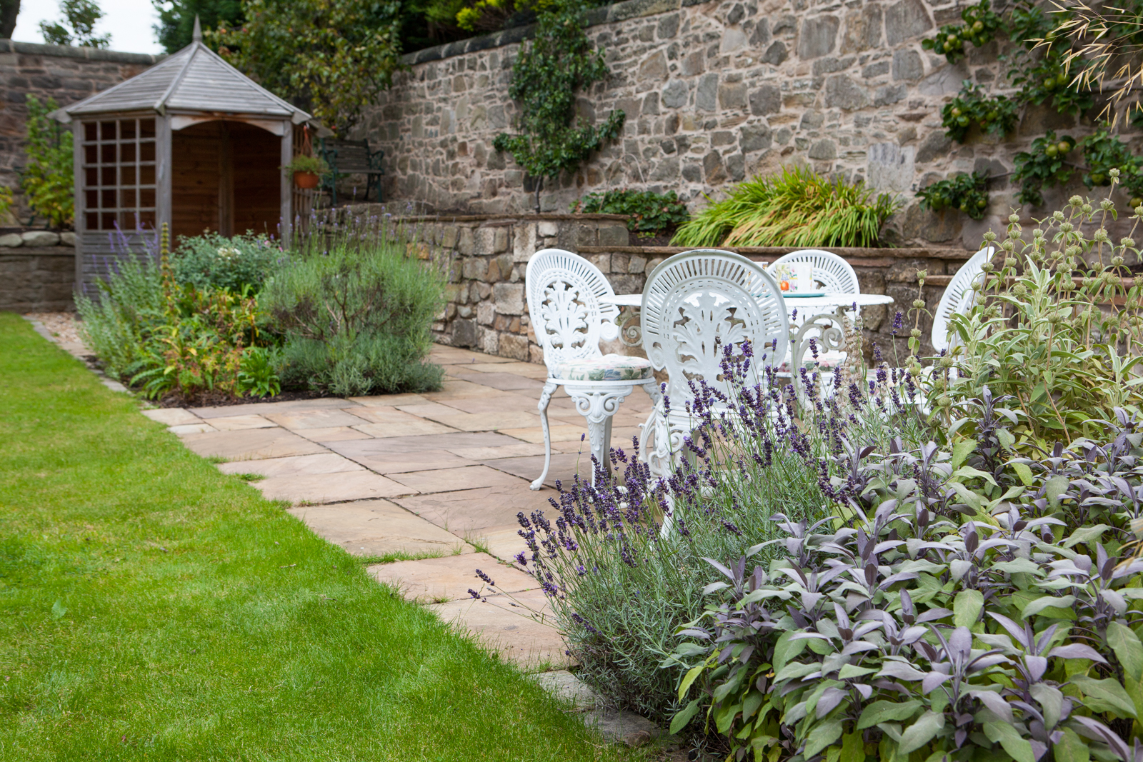 Seating and summer house in a stone walled garden