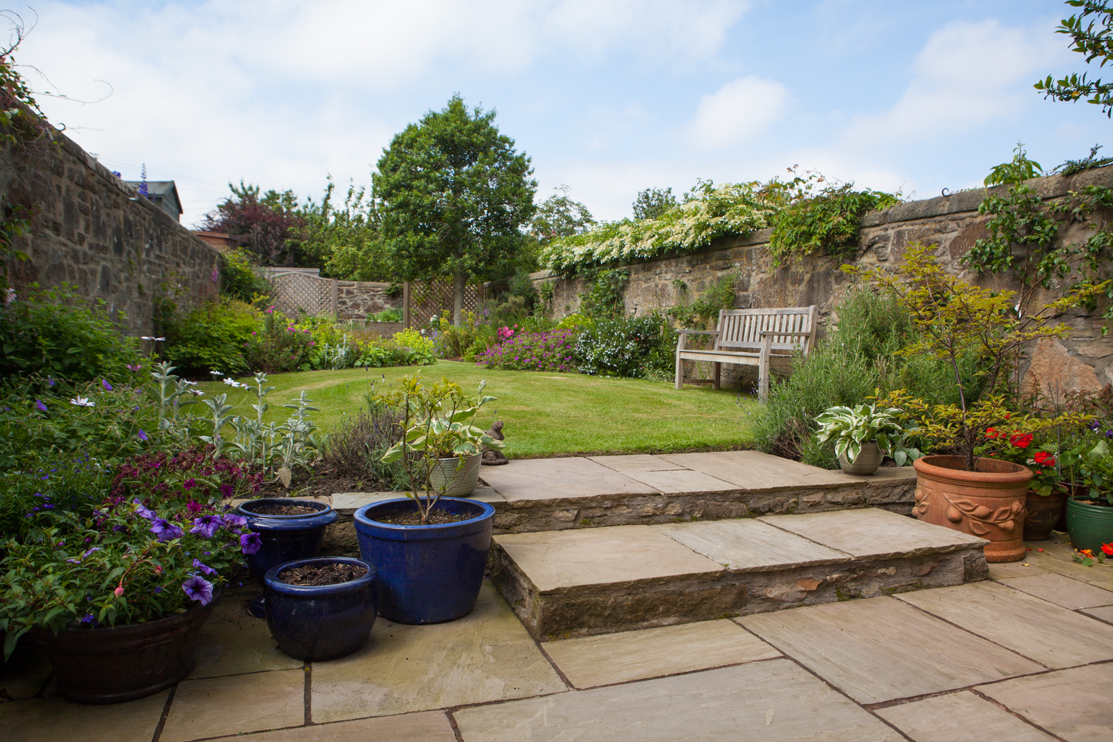 A multi level walled garden with various seating areas