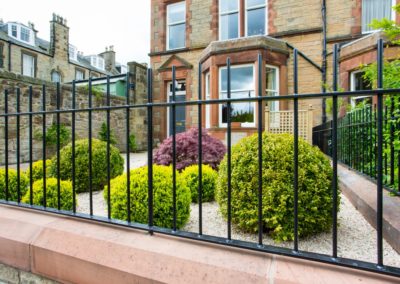 A small front garden with gravel, box balls and an acer