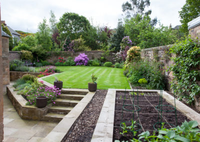 Sunny Walled Garden with multiple levels of planting and lawn